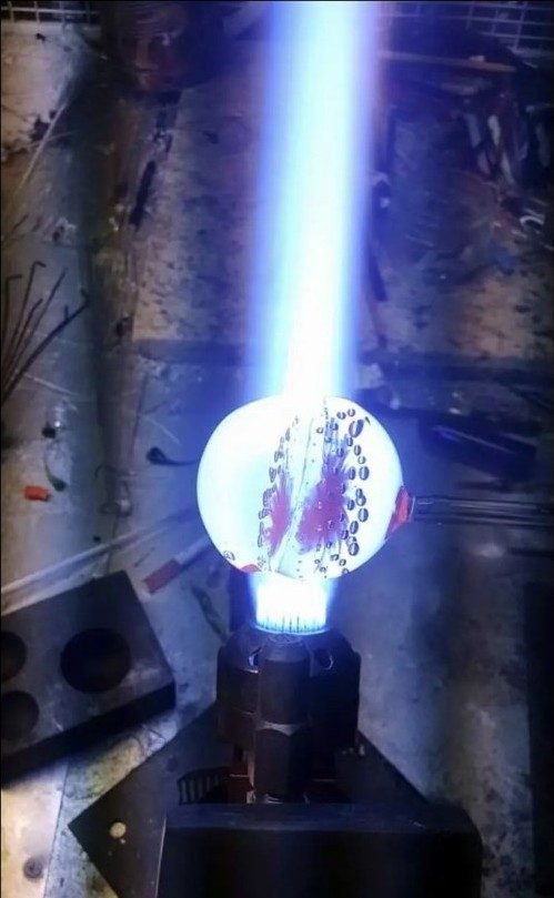 A large borosilicate glass implosion being worked at the torch by Jose Valdes